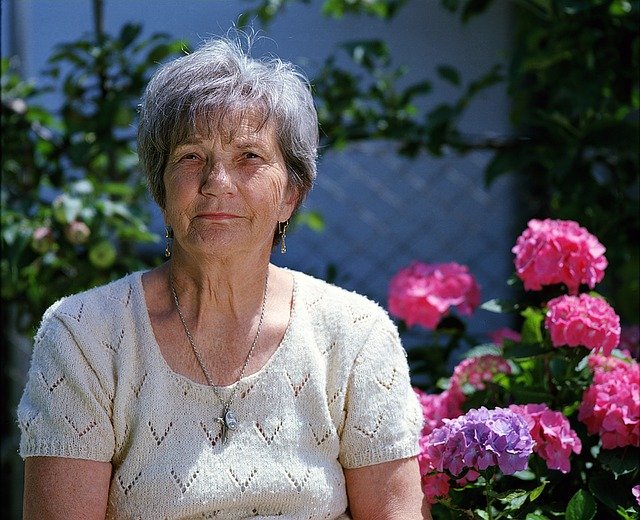 sénior en maison de retraite avec fleurs en fond