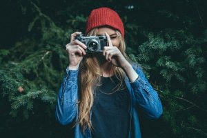 femme avec un appareil photo reflex de face prenant une photo